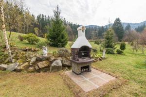a brick oven in a yard with a stone wall at Dom w Górach Stołowych MyWeek in Wambierzyce