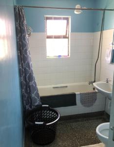 Sandrock Residence في نيروبي: حمام مع حوض استحمام ومغسلة