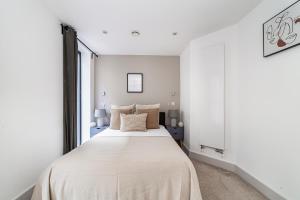 Schlafzimmer mit einem großen weißen Bett und einem Fenster in der Unterkunft The Old Street Luxury Flat in London