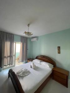una camera da letto con un letto con lenzuola bianche e una finestra di Guesthouse NEO a Tirana