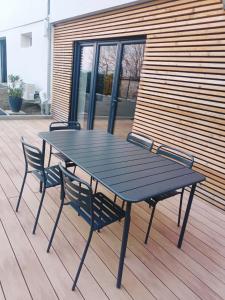 ein schwarzer Picknicktisch und zwei Stühle auf einer Terrasse in der Unterkunft L'Annexe - logement en Champagne in Pargny-lès-Reims