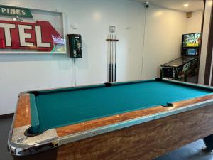 una mesa de billar en una habitación con un videojuego en Lake 'N Pines Motel, en Cooperstown