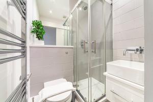 a bathroom with a shower and a toilet and a sink at The Old Street Luxury Flat in London