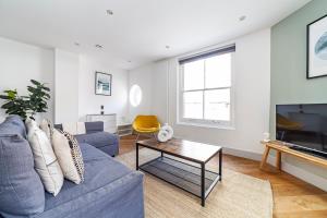 a living room with a blue couch and a tv at The Old Street Luxury Flat in London