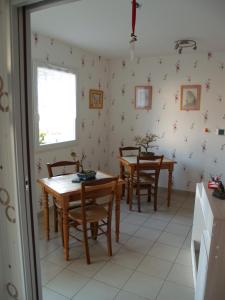 - une salle à manger avec deux tables et des chaises en bois dans l'établissement Le Rouge-gorge du Pescofi, à Portet-sur-Garonne