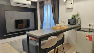 a kitchen with a table with chairs and a microwave at A4. The Moon @ Aurora Bukit Jalil in Kuala Lumpur