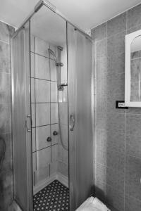 a shower with a glass door in a bathroom at Olympia Hotel in Genoa