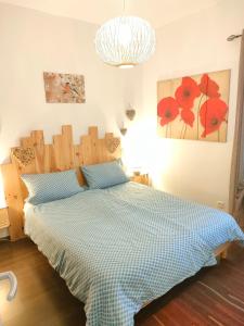 - une chambre avec un lit doté d'un couvre-lit bleu contrôlé dans l'établissement "Coeur d'elsass"Colmar centre bel appartement avec parking privé, à Colmar