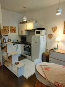 コルマールにある"Coeur d'elsass"Colmar centre bel appartement avec parking privéの小さなキッチン(白い家電製品、テーブル付)