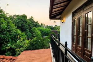 een balkon van een huis met uitzicht op bomen bij Roam Wings Safari Hotel in Udawalawe