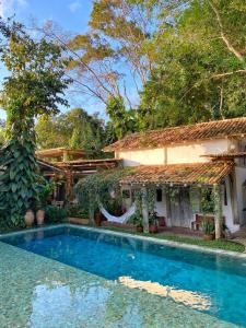 a house with a swimming pool in front of a house at Hotel Boutique Perainda in Trancoso