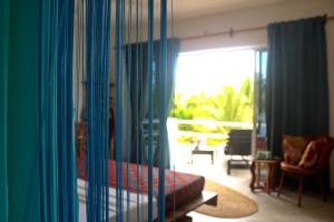 Cette chambre comprend un lit et offre une vue sur un balcon. dans l'établissement Aurora Boutique Hotel Jambiani, à Jambiani