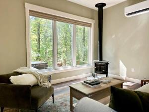a living room with a couch and a fireplace and a window at Brand New Modern Cottage Hocking Hills in Stella