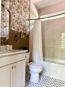 a bathroom with a toilet and a tub and a sink at Brand New Modern Cottage Hocking Hills in Stella