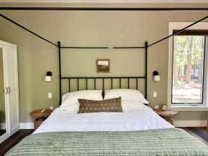 a bedroom with a large bed and a window at Brand New Modern Cottage Hocking Hills in Stella