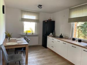 cocina con mesa y nevera negra en Ania, en Poniatowa