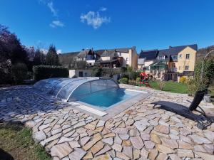 a swimming pool with a glass cover in a yard at Ferienhaus Lenz in Pünderich