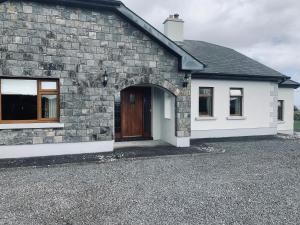 a brick house with a wooden door and a driveway at St John's B and B in Roscommon