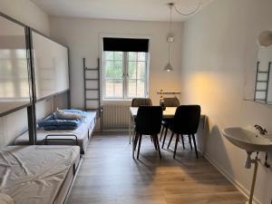 Zimmer mit einem Tisch, Stühlen und einem Bett in der Unterkunft Rønne Vandrerhjem in Rønne