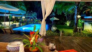 un tavolo di fronte alla piscina di notte di Maddekehaoo Eco Mansion a Ko Chang