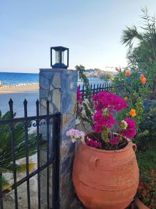 a large planter with flowers in front of a fence at Alexia Rooms in Káto Palaiokaryá