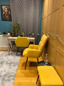 倫敦的住宿－Master En - Suite Townhouse double with Garden & Hot Tub，一间设有两张黄色椅子和一张桌子的房间
