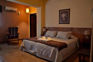 een slaapkamer met een groot bed en een stoel bij Portal del Sol in San Ignacio