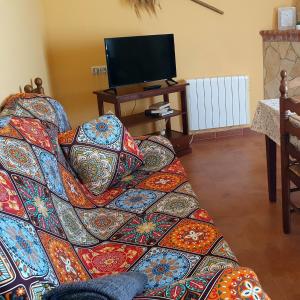 um sofá com almofadas coloridas numa sala de estar em Mirador de la cueva em Enguídanos