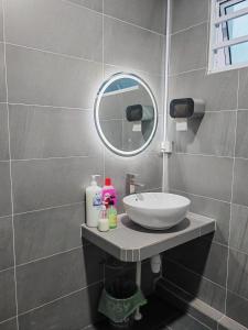a bathroom with a sink and a mirror at CEM MIRI HOMESTAY in Miri