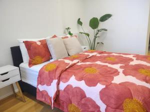 Un dormitorio con una cama con flores rojas. en Resort style 1 or 2 bedroom with pool and free parking en Hornsby