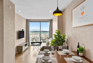 a dining room with a table and a view of a city at S Lux Apartment Virgo in Nha Trang