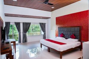 a bedroom with a bed with a red wall at 4 Bedroom Heaven in Munnar in Munnar