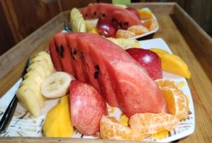 a plate of fruit on a wooden table at Roam Wings Safari Hotel in Udawalawe