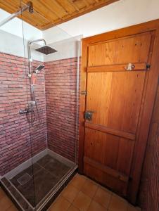 a bathroom with a shower with a wooden door at National Monument Konak in Stolac