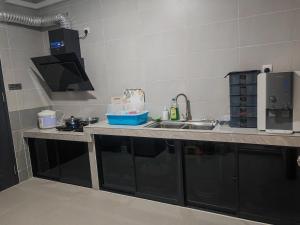 a kitchen with a sink and a counter top at CEM MIRI HOMESTAY in Miri