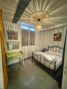 - une chambre avec un lit et un lustre dans l'établissement La galerie du peintre, à Saint-Laurent-de-la-Salanque