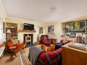 a living room with two couches and a fireplace at The Gardeners Cottage in Methven