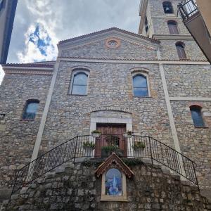 a large stone building with a clock tower at A Casa di Nonna in Castelsaraceno