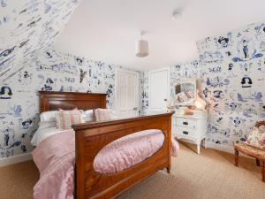 a bedroom with a bed with blue and white wallpaper at The Gardeners Cottage in Methven