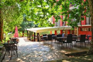 un patio con mesas y sillas bajo un dosel en Rilena Hotel en Kiten