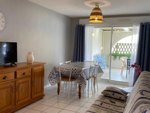 ein Esszimmer mit einem Tisch und einem TV in der Unterkunft Appartement Vieux-Boucau-les-Bains, 3 pièces, 6 personnes - FR-1-379-17 in Vieux-Boucau-les-Bains