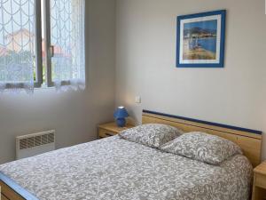 ein Schlafzimmer mit einem Bett und einem Bild an der Wand in der Unterkunft Appartement Vieux-Boucau-les-Bains, 3 pièces, 6 personnes - FR-1-379-17 in Vieux-Boucau-les-Bains