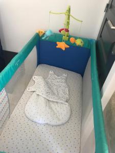 - un lit bébé dans une chambre avec un lit bébé dans l'établissement residence julius aéroport tillé classé 3 étoiles, à Tillé