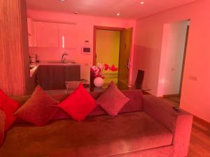 a living room with a couch with red pillows at Appartement Casa-marina au 10ème étage in Casablanca