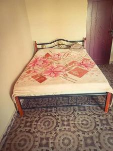sypialnia z łóżkiem z różowymi kwiatami w obiekcie The Aladin House w mieście Tujering