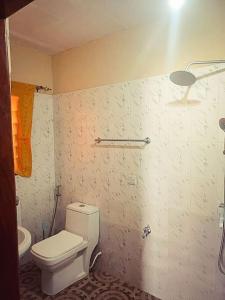 a bathroom with a white toilet and a sink at The Aladin House in Tujering