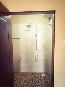 W łazience znajduje się prysznic ze szklanymi drzwiami. w obiekcie The Aladin House w mieście Tujering