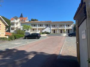 滨海圣帕莱VUE MER et SOLEIL LEVANT AU BELVEDERE的停在建筑物前停车场的汽车