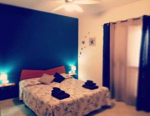 um quarto com uma cama com uma parede azul em Bed & Breakfast Gli Alisei em Siniscola