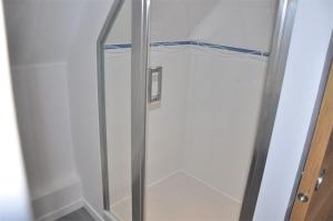 W łazience znajduje się prysznic ze szklanymi drzwiami. w obiekcie Appartement rénovée SUPERBE VUE MER au 2ème étage du Château de Trestraou - Réf 864 w mieście Perros-Guirec